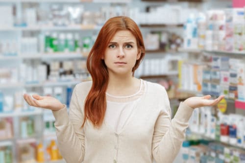 Need help. Portrait of a young frustrated woman looking to the camera at the local drugstore.